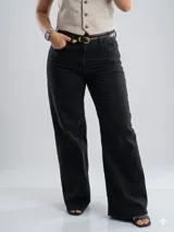 Jean de corte wide leg en color negro con efecto de desgaste. Presenta tiro medio, diseño de cinco bolsillos y cierre frontal con botón y cremallera.