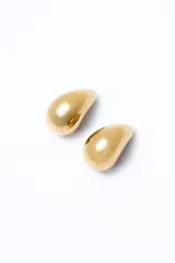 Aros colgantes dorados con forma de gota.