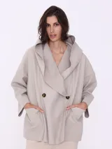 Saco espigado color beige, de corte holgado, con cuello solapa y doble botonadura.