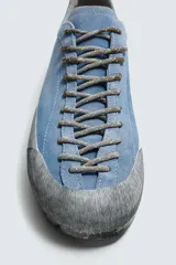 Zapatilla de cordones con diseño de inspiración montañista, confeccionada en piel con acabado de serraje en color azul. Presenta una puntera y refuerzo lateral en gamuza gris con textura desgastada, horma redonda y suela de goma dentada VIBRAM®.