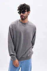 Buzo deportivo gris oscuro con efecto lavado, cuello redondo y corte holgado.