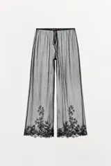 Pantalón semitransparente de tiro medio, pernera recta, cintura ajustable con lazada y detalle de bordados a tono en el bajo.