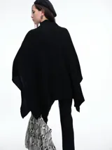 Poncho amplio de cuello alto, confeccionado en hilado con lana y cashmere, con diseño de caída recta y botones laterales.