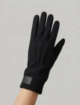 Guantes de tejido soft color negro, con diseño liso y puño elastizado.