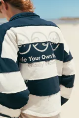 Buzo estilo rugby de corte oversize, con diseño de rayas horizontales anchas en blanco y negro. Presenta cuello tipo polo, costuras expuestas con efecto desflecado y el logo de la marca estampado en el pecho.