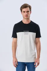Remera de algodón y poliéster de corte clásico, con diseño en bloques de color negro en la parte superior y gris melange en la inferior. Presenta cuello redondo, mangas cortas y un pequeño estampado tipográfico en el pecho.