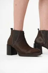 Botas Chelsea de cuero con pelo color marrón oscuro, con elásticos laterales y cierre interno. Taco bloque de madera y plataforma delantera.