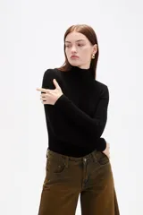 Polera de viscosa color negro, de corte ajustado al cuerpo, con cuello alto y mangas largas.