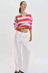 Sweater de punto con diseño de rayas horizontales en rojo y celeste, cuello polo blanco con escote en V y manga larga.