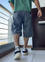 Bermuda de jean gris oscuro con lavado gastado, corte ancho y largo a la rodilla.