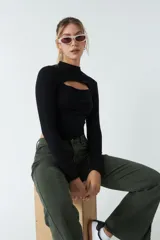 Top rojo de punto canalé, de manga larga y cuello alto con abertura en el pecho.