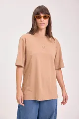 Remera de algodón color camel, corte holgado y manga corta, con un pequeño bordado de un sol en el pecho.
