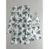 Conjunto de traje de baño de tres piezas con estampado de hojas tropicales en tonos blanco y negro. Incluye un top tipo tankini con cordón ajustable en el centro, un short de tiro alto y una camisa abierta de manga larga tipo salida de baño.