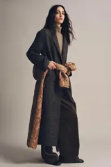Abrigo largo de Zara Woman Collection, confeccionado en tejido con mezcla de lana. Presenta un diseño de cuadros, cuello con solapas de muesca, cierre frontal cruzado con botones y bolsillos delanteros. Incluye forro interior.