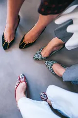 Zapatos de tacón de línea clásica confeccionados en terciopelo negro con aplicaciones de plata. Presentan un diseño estructurado con puntera, laterales y talonera divididos por ribetes en piel tornasolada, con interior en piel y suela de cuero.