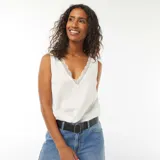 Blusa blanca sin mangas con escote en V y detalle de encaje en el borde.