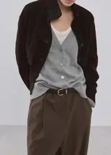 Cardigan gris de punto con escote en V, cierre frontal abotonado y mangas largas, diseño clásico y versátil.