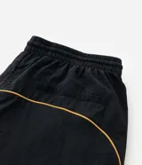 Pantalón deportivo de microfibra color negro, con corte holgado y diseño de piping contrastante en color amarillo. Cuenta con cintura elástica con cordón de ajuste, bolsillos laterales y logo bordado.