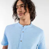 Camisa celeste de manga corta con cuello mao y cierre frontal de botones, confeccionada en mezcla de lino.