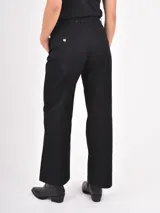 Pantalon de corte recto y tiro medio, confeccionado en tela de algodón color negro, con cierre frontal y bolsillos laterales.