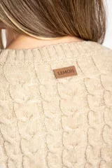 Sweater de punto con diseño de trenzas verticales, cuello redondo y corte oversize. Presenta puños y ruedo acanalados anchos.