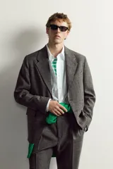 Blazer regular fit de Zara, confeccionada en tejido con mezcla de lana y lino en color gris oscuro con efecto jaspeado. Presenta cuello con solapas de muesca, manga larga con botones en los puños y un cierre frontal de un botón. Incluye bolsillos con solapa en la cadera, un bolsillo de vivo en el pecho y aberturas en la parte trasera.