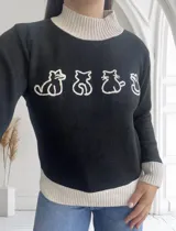 Sweater negro de punto con cuello alto y ribete color crema en cuello, puños y ruedo. Presenta un bordado de siluetas de gatos en color crema en el frente.