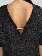 Vestido corto de punto con hilos metálicos que aportan un brillo sutil. Presenta un calce relajado, cuello redondo, mangas cortas y espalda en V pronunciada con detalle de dije metálico.