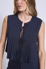 Blusa sin mangas color azul marino, con cuello redondo y detalle de tablas verticales en el frente. Corte holgado y corto.