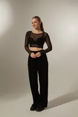 Pantalon de corte recto y tiro alto, confeccionado en tela de terciopelo negro con costuras verticales decorativas en el frente.