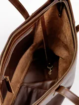 Cartera tote de cuero natural color beige, con doble asa larga para hombro y cierre superior con broche.
