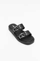 Sandalias negras de plataforma de 2,5 cm de alto, con dos tiras anchas en símil cuero y detalles metálicos plateados en forma de hebillas y remaches.