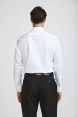 Camisa de vestir blanca de corte clásico, con cuello rígido, cierre frontal de botones y mangas largas con puños abotonados.