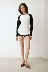 Remera de manga larga estilo raglan, color verde militar, con cuello redondo y dobladillo inferior curvado.