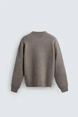 Jersey de punto con textura efecto pelo, corte boxy fit, cuello redondo y manga larga con acabados en rib.