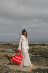 Bolso tipo tote tejido a crochet con hilo de algodón color marrón y crudo, con diseño a rayas horizontales y volados en los bordes.