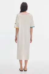 Vestido midi de punto calado color marfil, con cuello polo abierto y detalles de vivos en contraste de colores en el cuello y las mangas.