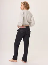 Pantalón negro de corte cigarette, pierna angosta con abertura en el tobillo y costuras en contraste color ocre. Presenta un tiro bajo con un detalle de etiqueta roja en la parte trasera de la cintura.