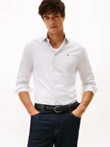 Camisa de manga larga Tommy Hilfiger con corte slim, confeccionada en algodón. Presenta un estampado de micro puntos, cuello clásico y cierre frontal con botones. Incluye el logo de la marca bordado en el pecho.