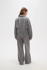 Campera de estilo deportivo en color gris, con cuello solapa, cierre frontal completo y mangas largas con puños ajustados. Presenta un diseño holgado con cintura elástica.