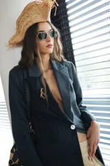 Blazer de sastrería con diseño asimétrico que combina dos tonos de gris con sutil estampado a rayas. Presenta solapas clásicas, cierre frontal con un botón de nácar y bolsillos con tapa.