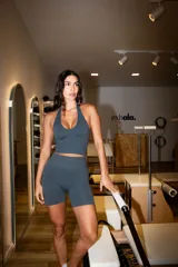 Musculosa deportiva de cuello halter, confeccionada en tejido mate de color bordó, con diseño ajustado al cuerpo y largo cropped.