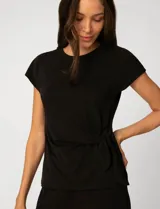 Remera de manga corta color negro, con cuello redondo y detalle de lazo lateral que genera un drapeado natural en la cintura.