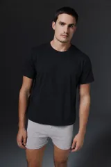 Pack de dos remeras de algodón, una blanca y una negra, con cuello redondo y etiqueta de la marca Carouomo en el interior.