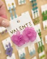 Caravanas de diseño floral en color fucsia, elaboradas en material acrílico traslúcido con acabado mate.