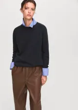 Pantalón efecto piel de color marrón, con diseño recto, tiro medio y cintura elástica con cordón ajustable. Cuenta con dos bolsillos laterales.