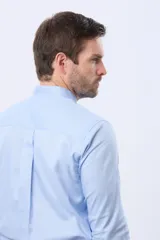 Camisa lisa de color celeste, confeccionada en 100% algodón, con cuello mao y cierre frontal de botones.
