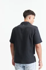 Camisa de manga corta color crema con textura, cuello clásico y calce regular.