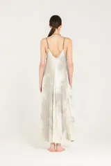 Vestido lencero de satén liviano de viscosa con breteles regulables, degradé hecho a mano y sobreteñido. Presenta escote en V, silueta evasé con vuelo, largo hasta el tobillo, bolsillos laterales, espalda baja en V y ruedo asimétrico.
