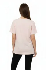 Remera de algodón negra con cuello redondo y mangas cortas. Presenta un estampado frontal con la frase 'WANTED AND WILD', gráficos de revólveres, estrellas y texto alusivo a un festival western.